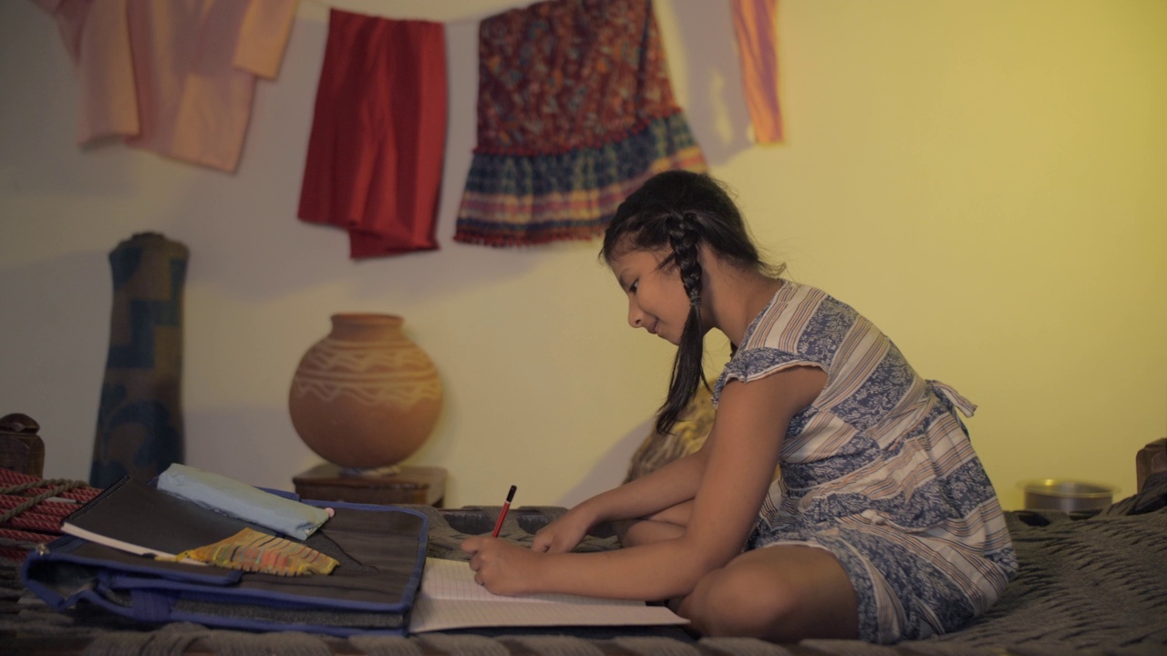 村庄里一个可爱的小女孩正在做作业——左手写字，左手写字视频素材