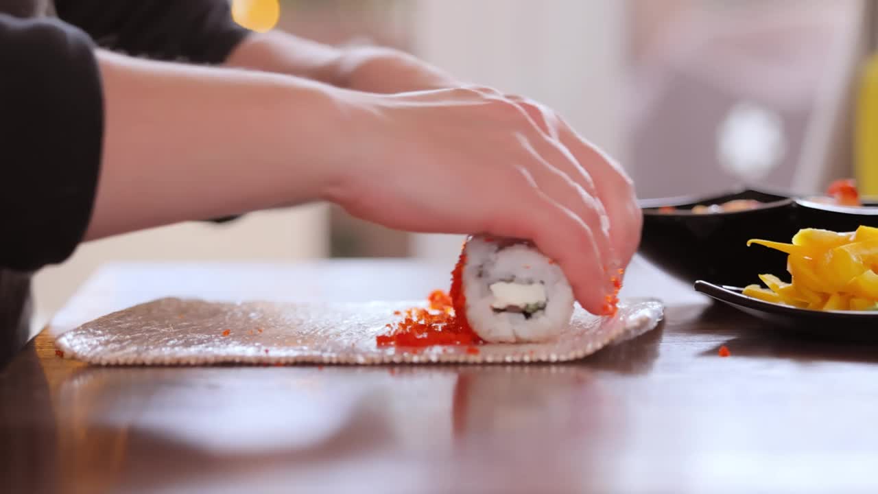 在家做寿司。女人双手卷着自制寿司。视频素材