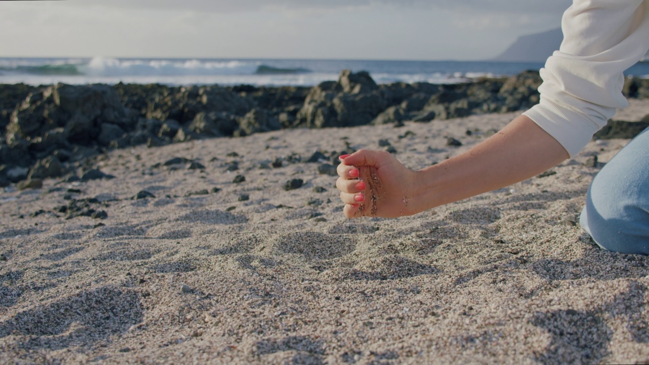 热带沙滩上，年轻女子手持白沙。特内里费视频素材