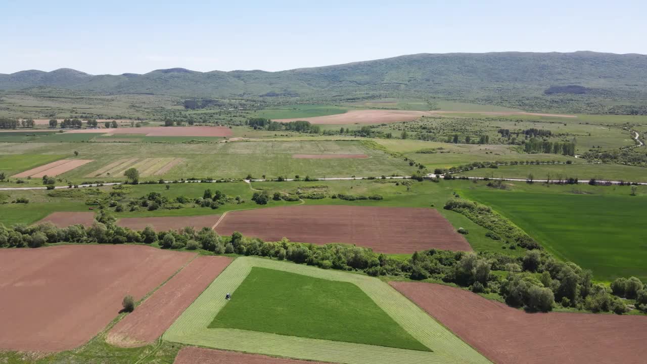 春天鸟瞰保加利亚城镇附近的农村土地视频素材