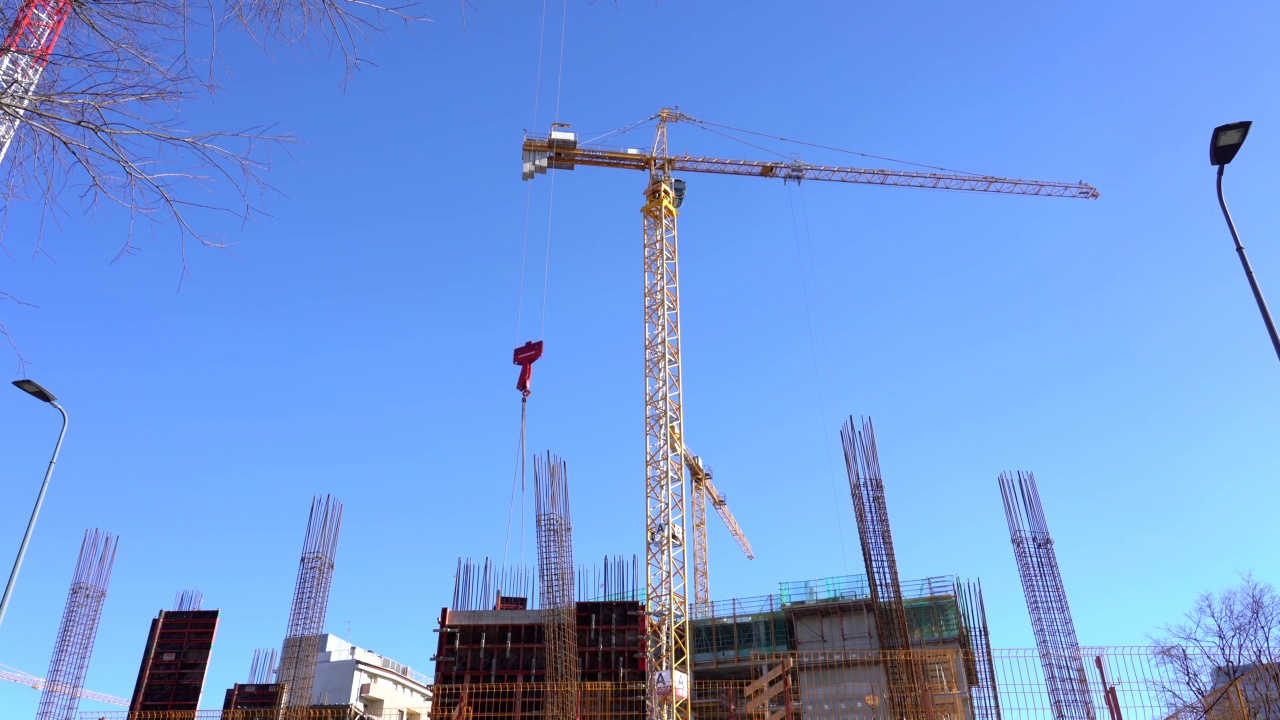 欧洲，意大利，米兰2021年2月-
一座新建筑的施工现场——正在施工的起重机和浇筑地基钢筋混凝土的铁柱——天际线视频素材