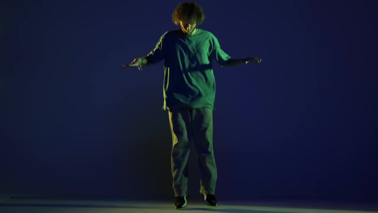 时髦的年轻人，嘻哈舞者在霓虹灯下的深蓝色背景上跳舞。现代舞艺术、时尚、青春、广告、风格。4 k、视频视频素材