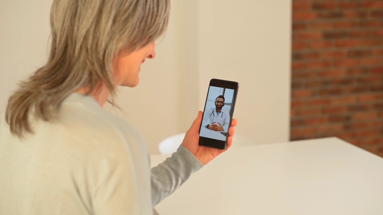 成熟女性在家与医生在线聊天，进行虚拟体检视频素材