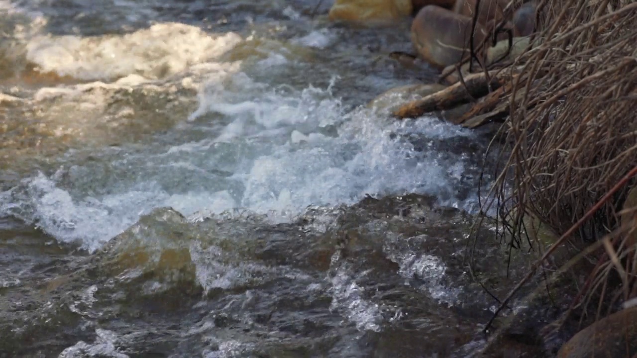 阳光明媚的日子里，河流流过岩石，特写细节，湍急的白水，慢动作视频视频素材