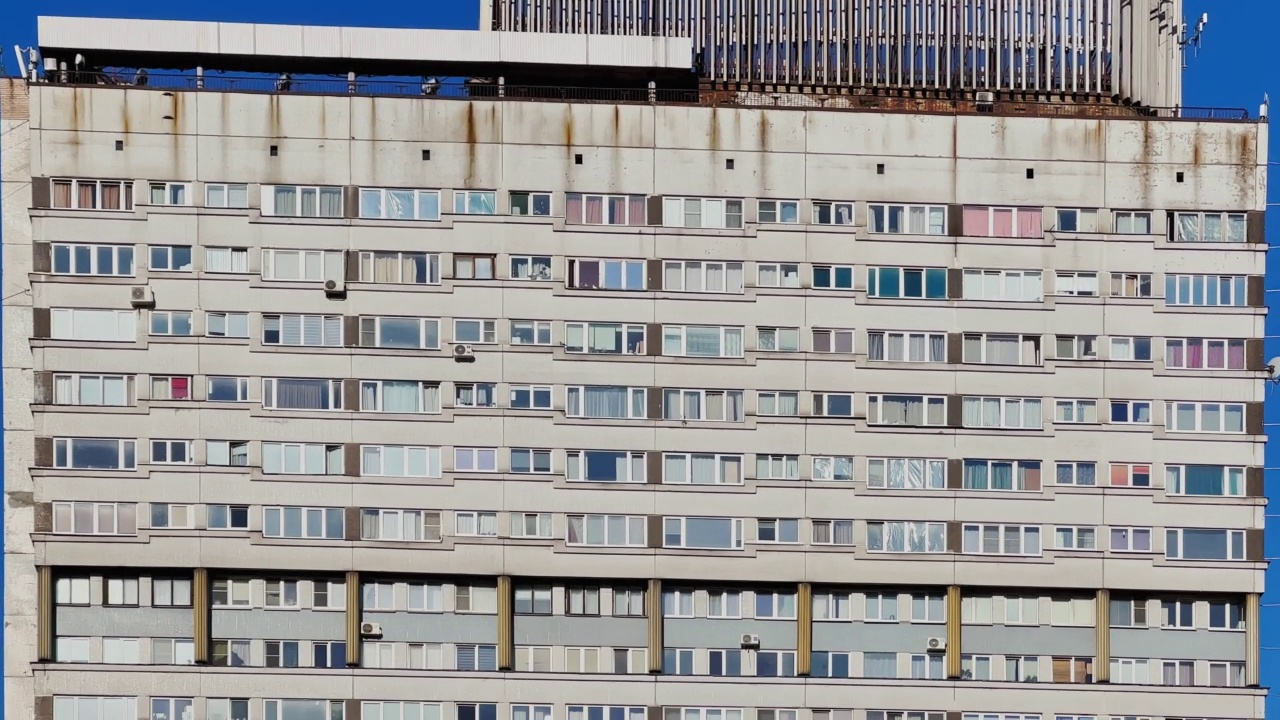 一幢苏联旧居民楼的阴暗立面，一排窗户，一个贫民区视频素材