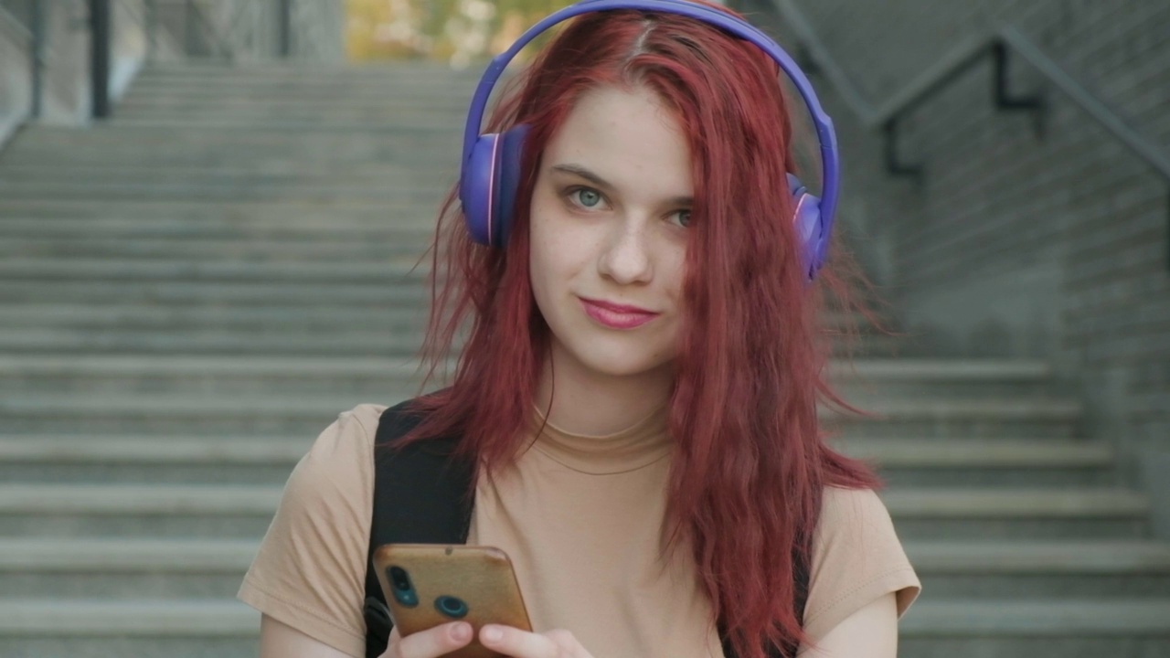用智能手机听音乐的快乐可爱女人的特写肖像视频素材
