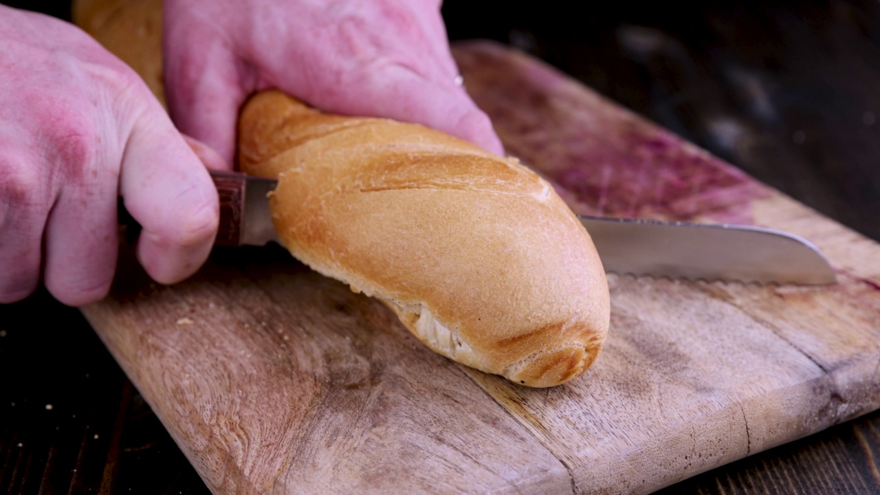 在烹饪时将新鲜脆的小麦法棍切成小块视频素材