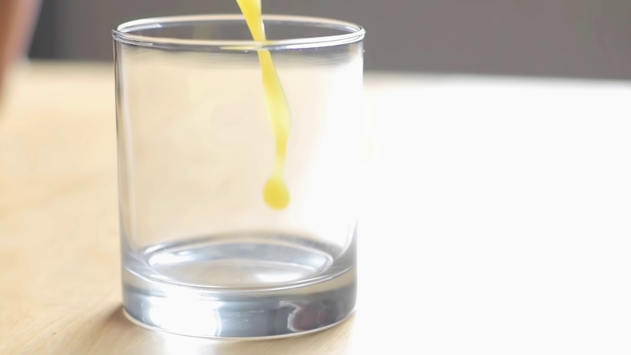 把橙汁倒在空杯子上的慢动作视频素材