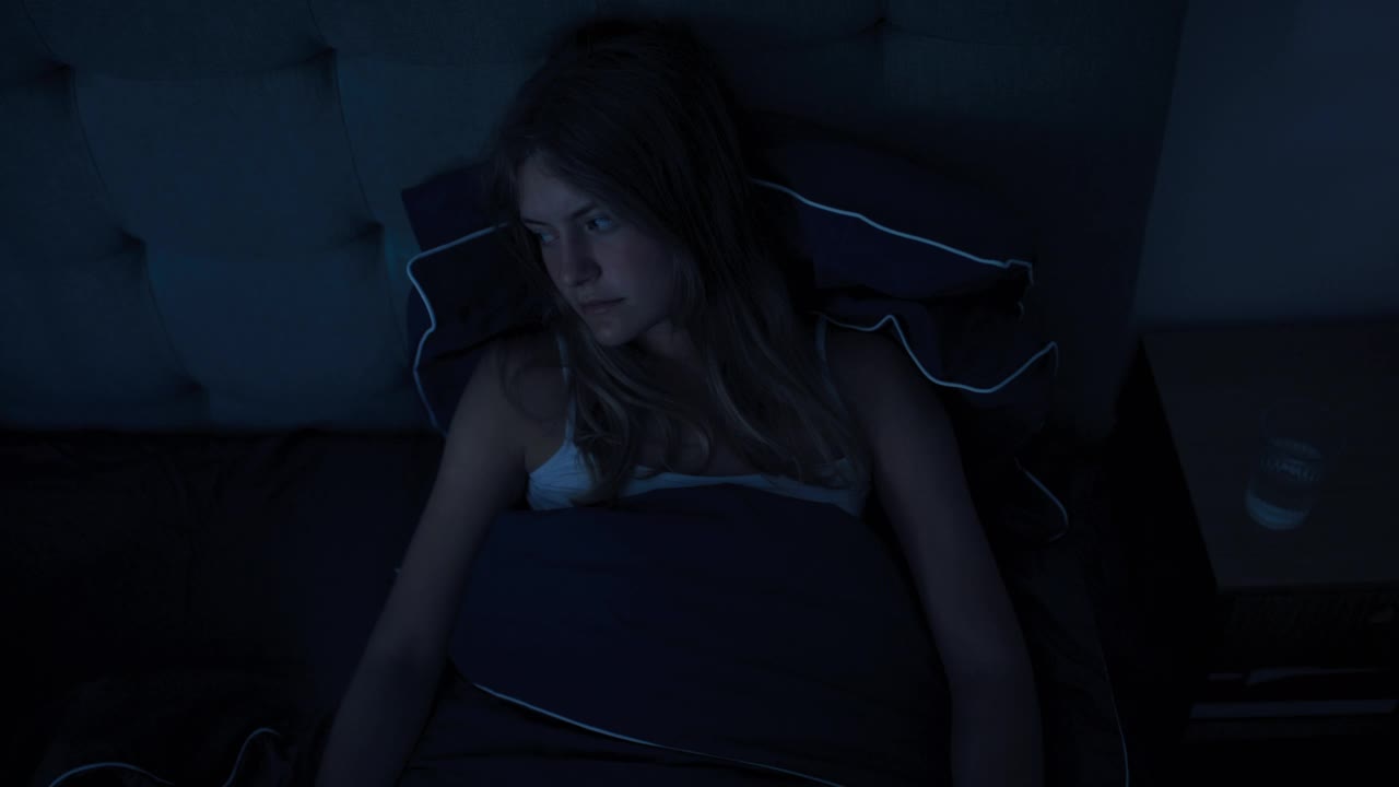 女人在床上因失眠而睡不着视频素材