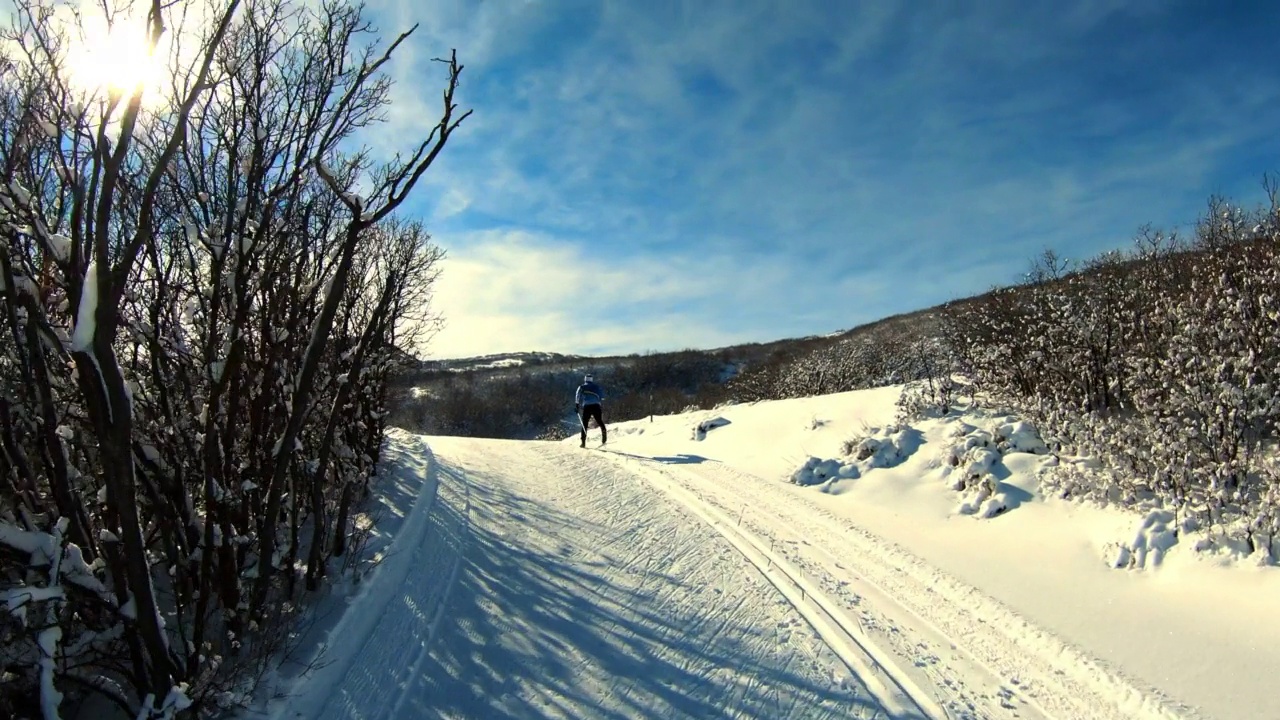 空中拍摄的人滑雪景观向山，无人机飞行向前在雪在晴朗的日子-士兵空心，犹他州视频下载