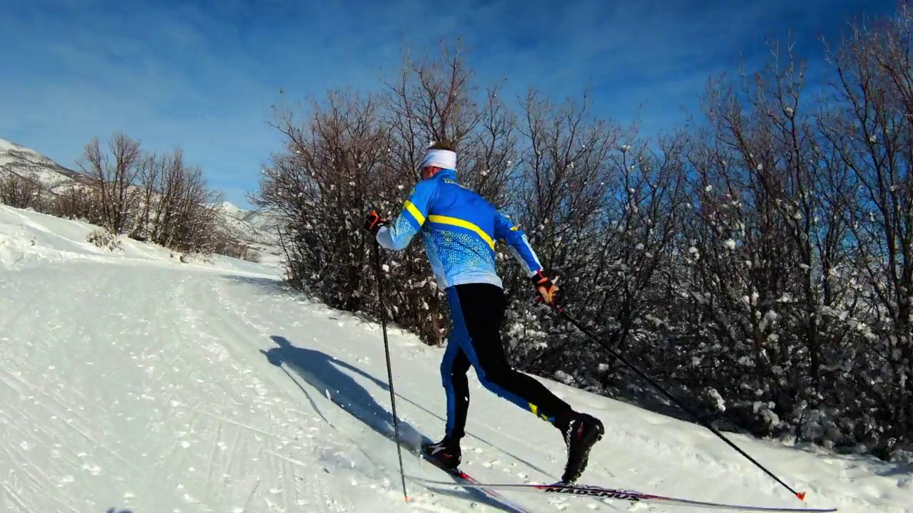 在阳光明媚的日子里，一名男子在斜坡上滑雪视频下载