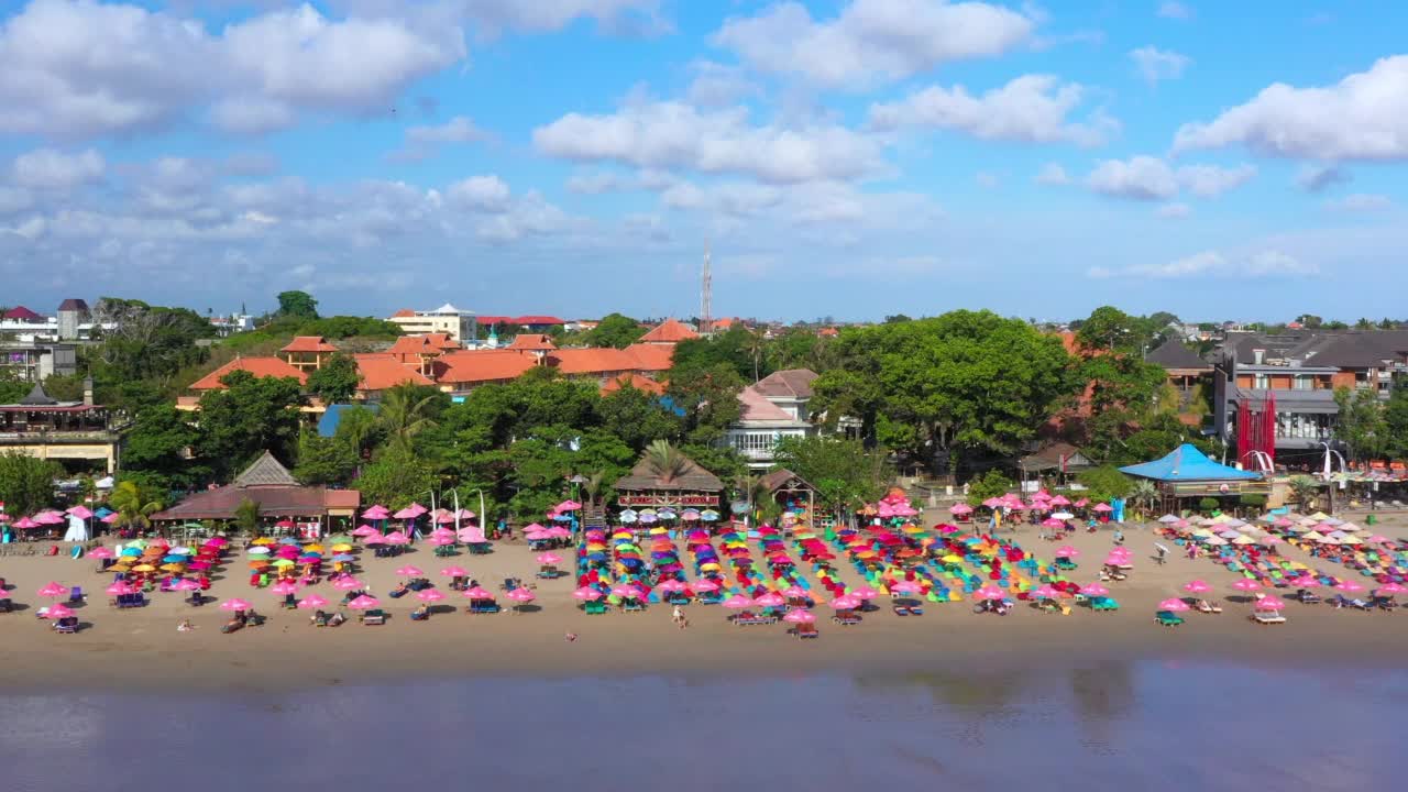 空中拖动一个拥挤的热带巴厘岛海滩与明亮的蓝色天空-库塔，印度尼西亚视频素材