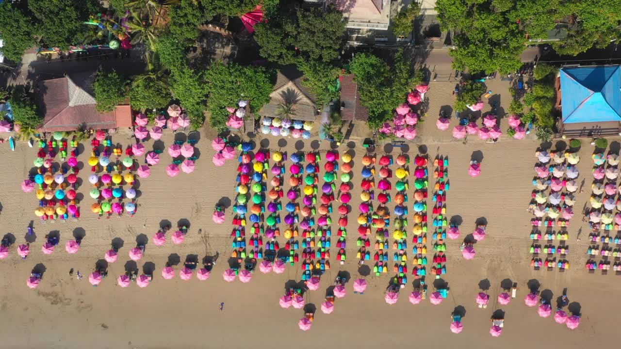 带着色彩鲜艳的伞，从拥挤的热带巴厘岛海滩上空俯瞰——印尼库塔视频下载