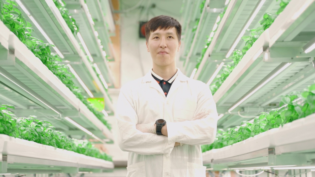 在科技城农场的温室里，年轻的亚洲男人的肖像视频素材