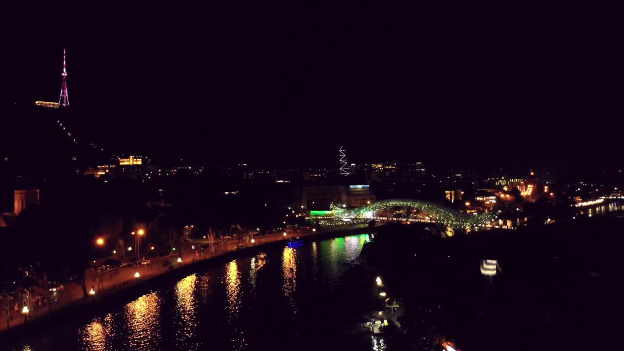 格鲁吉亚，第比利斯——2022年6月20日:格鲁吉亚美丽的首都第比利斯的空中全景，河岸在夜间灯火通明视频素材