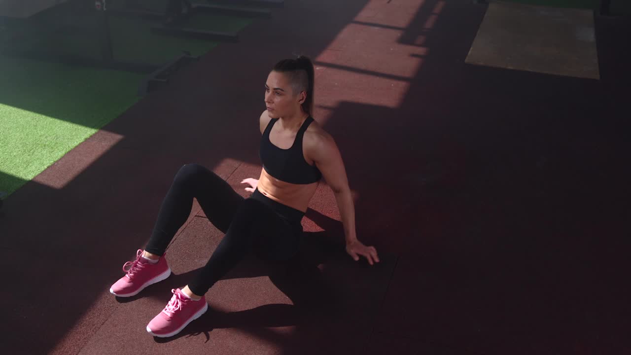 单身女运动员在健身房做仰卧起坐视频素材