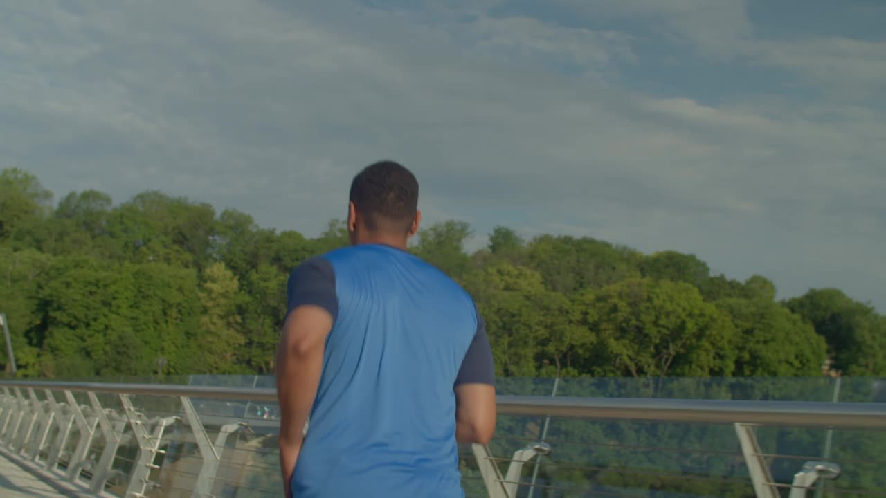 运动健身的非洲裔美国人的后视图，黎明在桥上慢跑视频素材