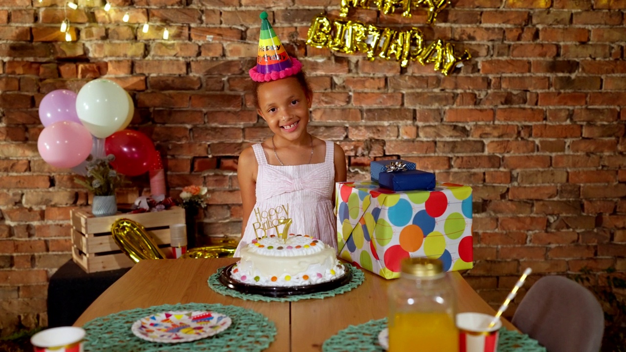 一个小女孩的肖像在她的生日和礼物和蛋糕在院子里视频素材