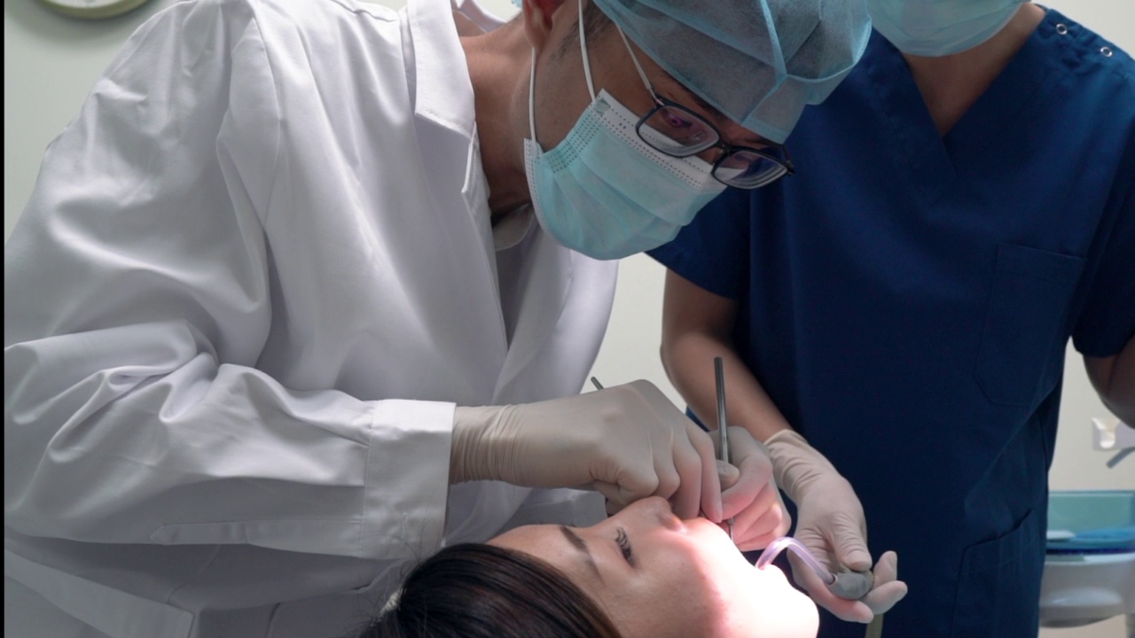 牙科护理-亚洲牙医检查病人的口腔状况视频素材