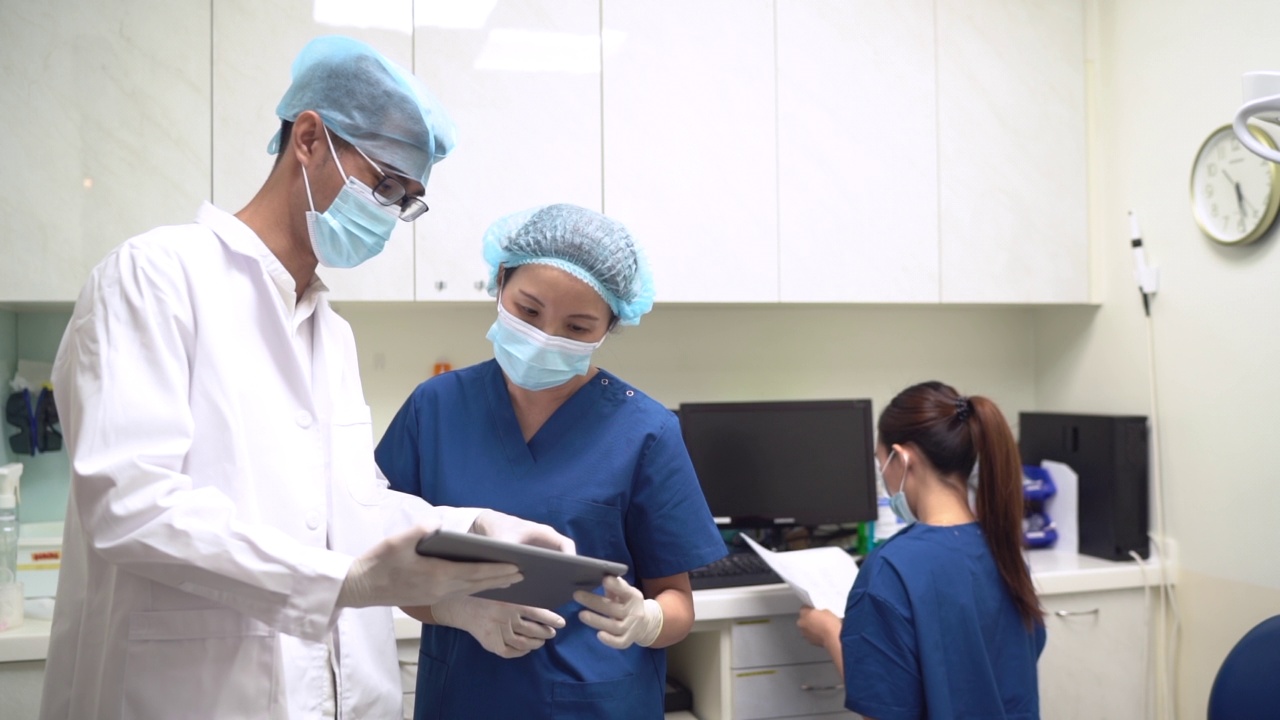 医疗行业。牙医和护士在牙科诊所讨论使用技术视频素材