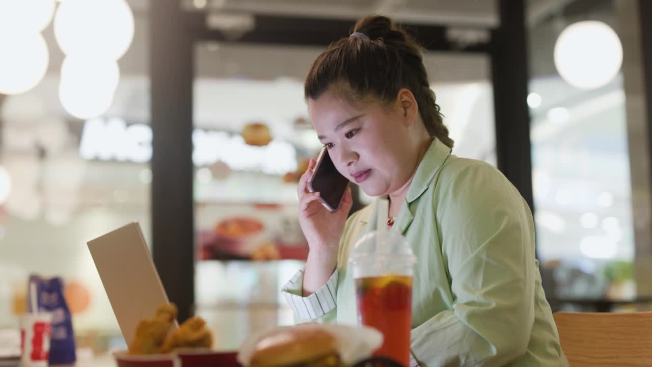 身材高大的女性在餐馆用手机联系商家视频下载