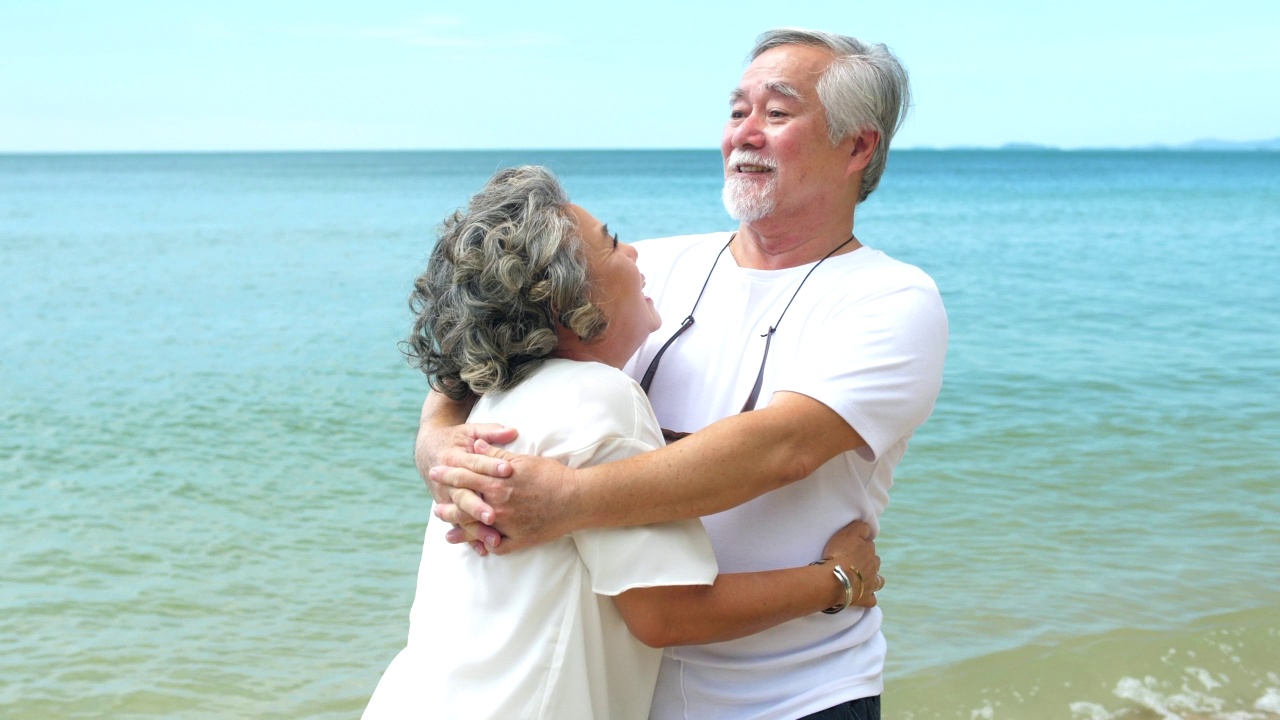亚洲老年夫妇喜欢在海滩上跳舞，享受浪漫的假期视频下载