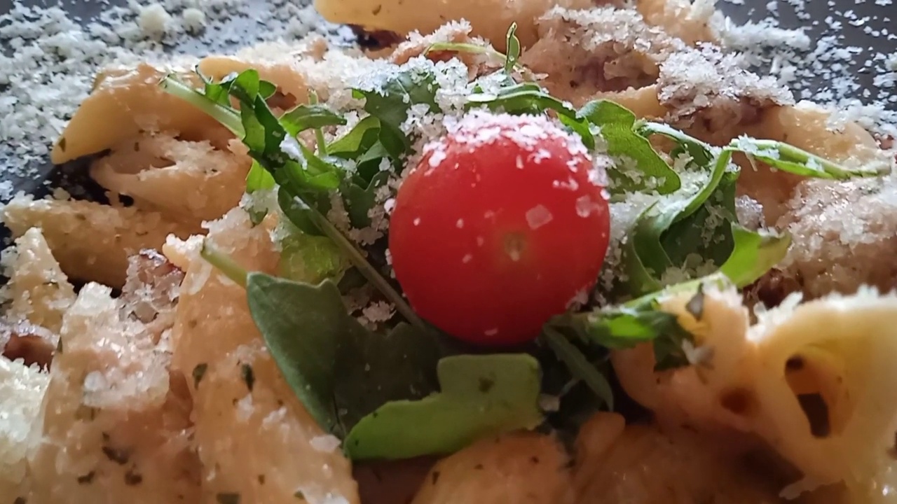 意大利面盘俯视图，樱桃番茄通心粉，沙拉和帕尔玛干酪。视频素材