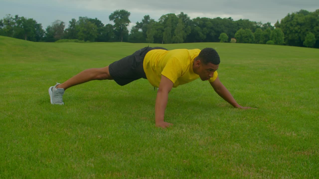 肌肉发达的非洲裔美国人在自然中做平板支撑伸展运动视频素材