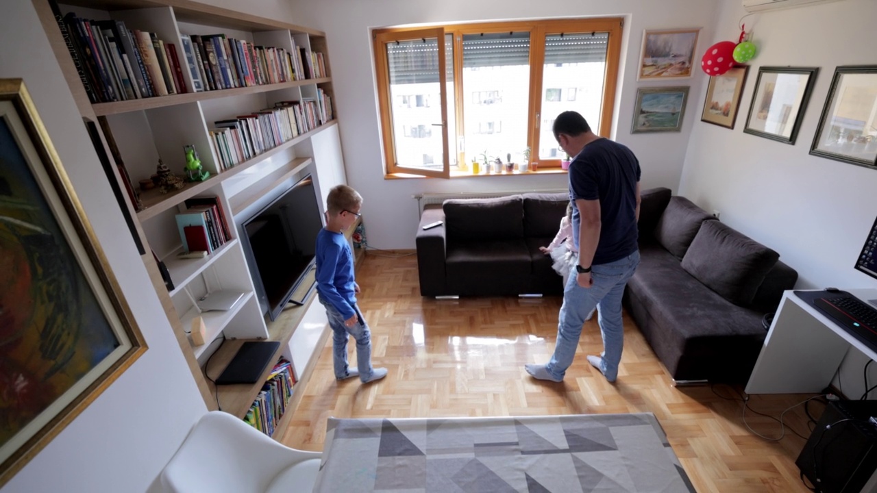 一个男人正在客厅里和孩子们踢足球视频素材