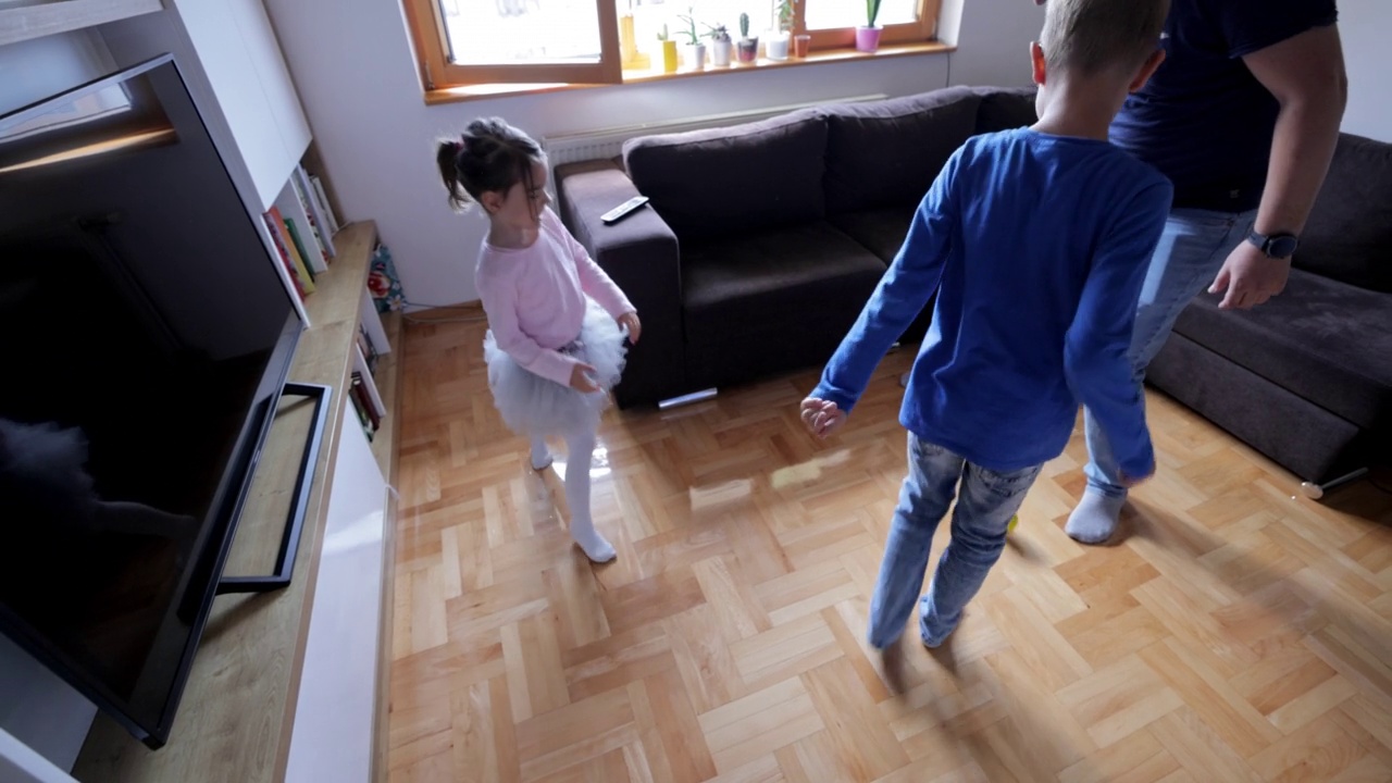 一个男人正在客厅里和孩子们踢足球视频素材