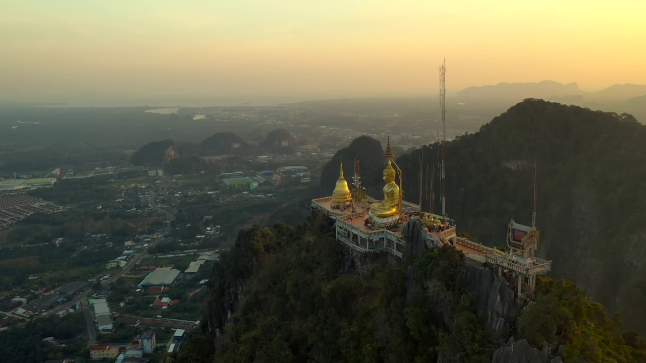 无人机拍摄的巨大的金佛雕像矗立在山顶上。泰国甲米虎洞寺。视频素材