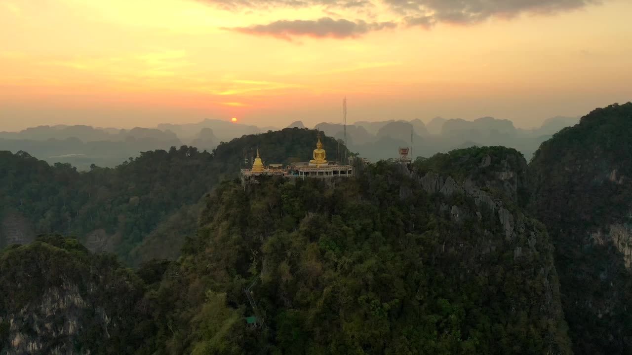 无人机拍摄的巨大的金佛雕像矗立在山顶上。泰国甲米虎洞寺。视频下载