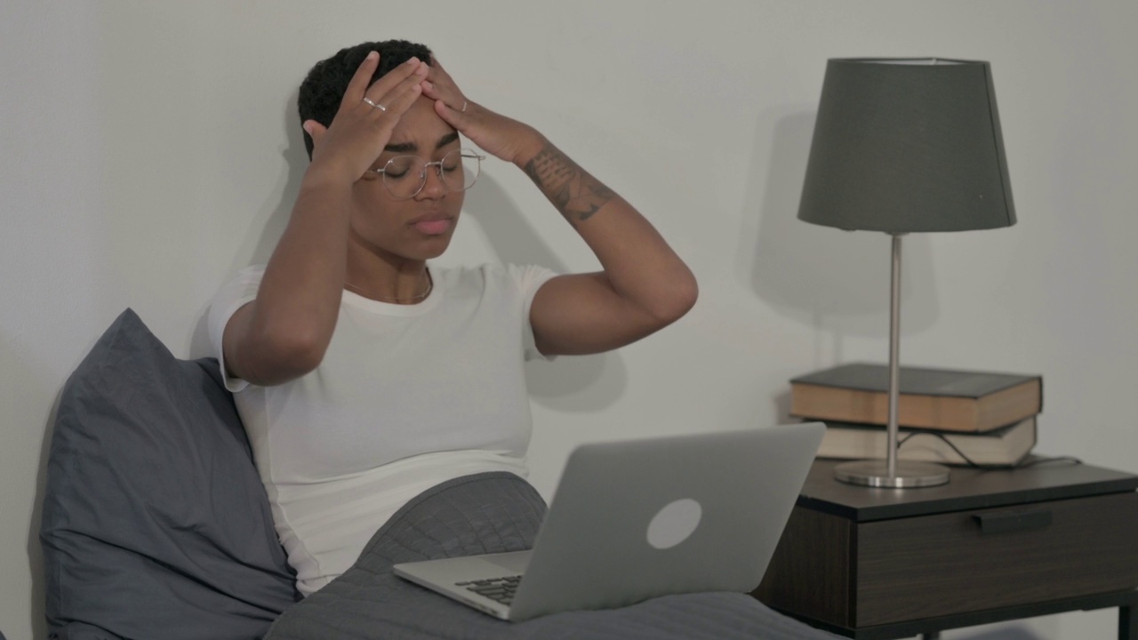 非洲妇女在床上丢失笔记本电脑的反应视频素材
