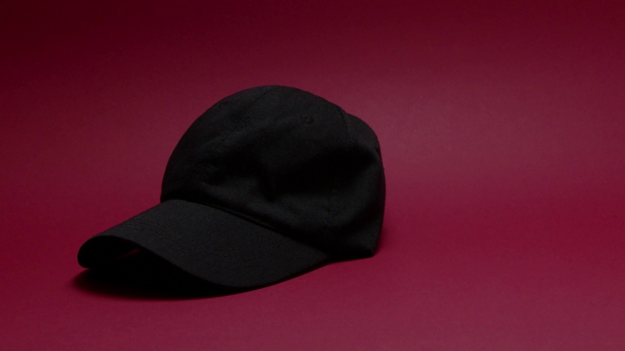 落在红色背景上的黑色帽子视频下载