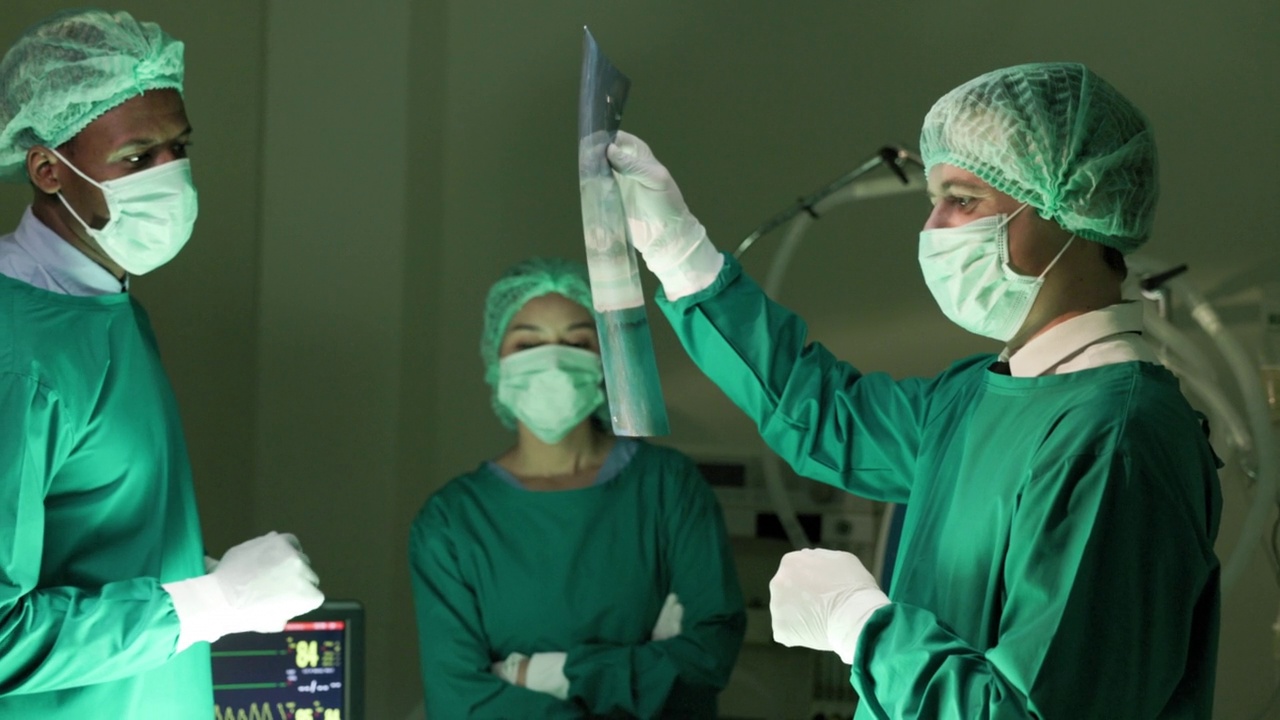 一小群医生正在医院的手术室里看病人的x光片。视频下载
