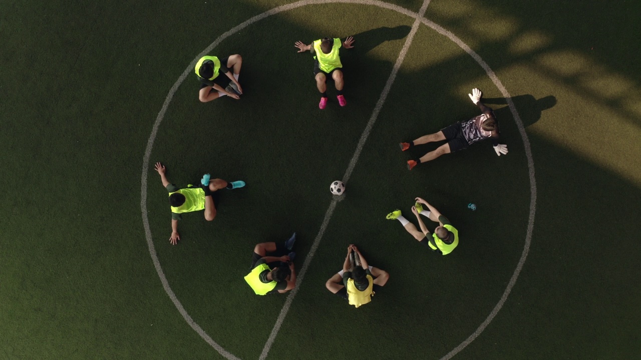 高角度视角:亚洲男子足球运动员与朋友打球。视频素材