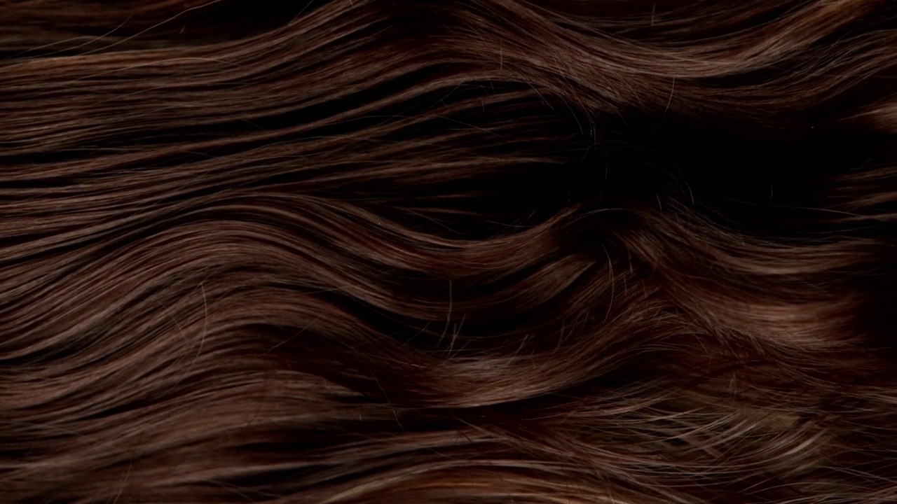 超慢动作的波浪棕色头发的细节。视频下载