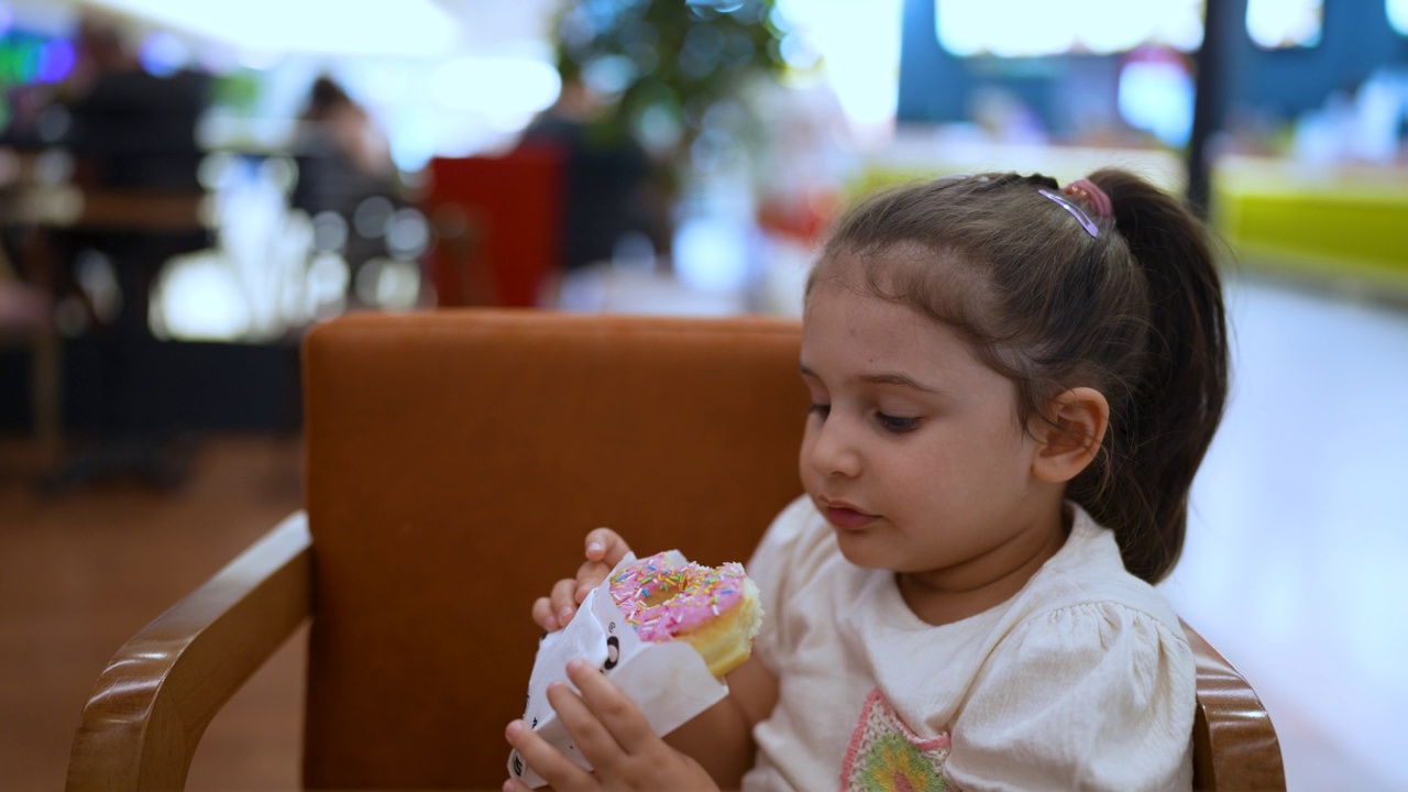 小女孩在吃甜甜圈视频素材