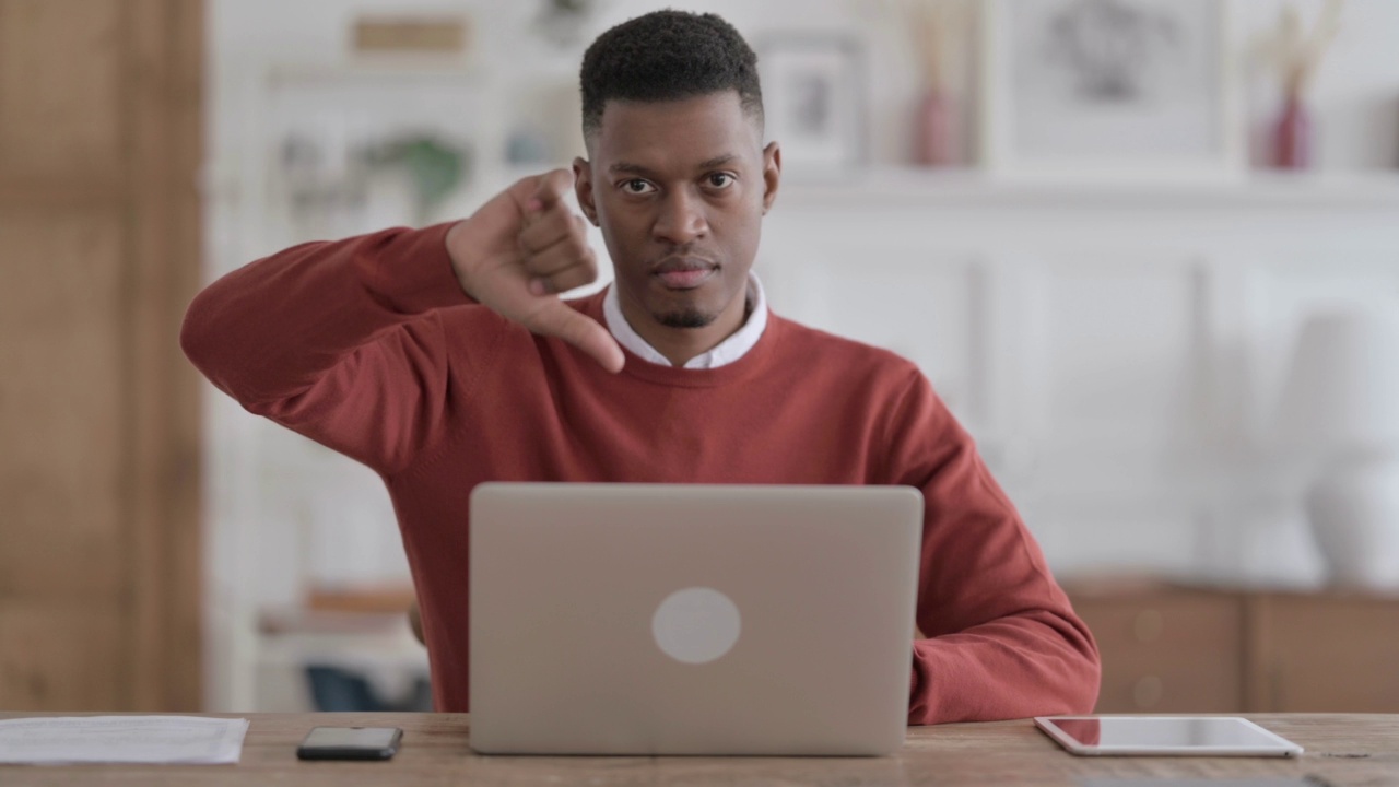 一名非洲男子在办公室使用笔记本电脑时表示反对视频素材