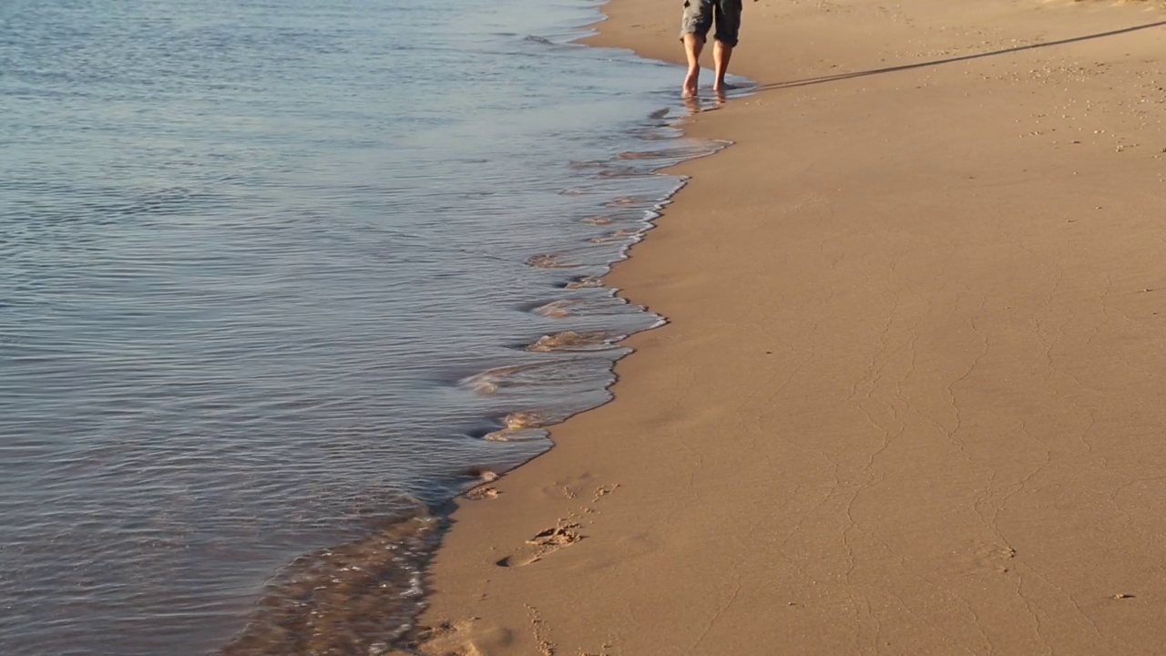 走在海边的人的脚在沙滩上留下脚印视频素材