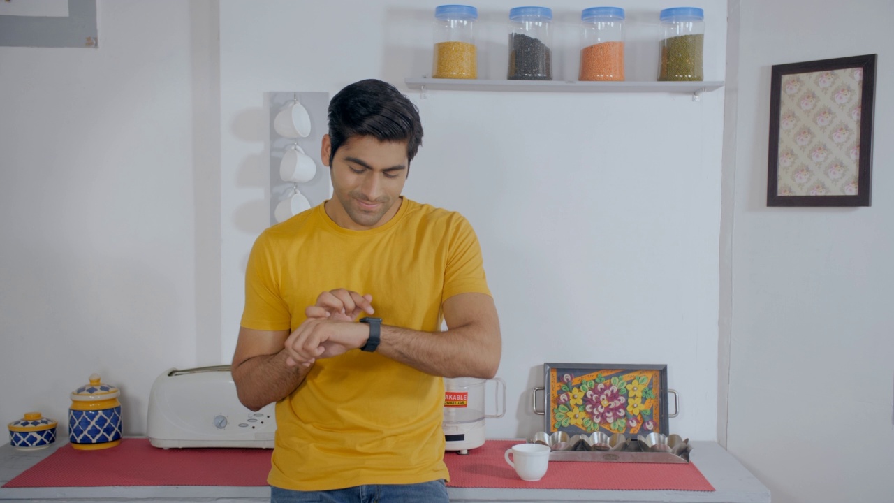 年轻的印度人检查他的智能手表-现代生活方式视频素材