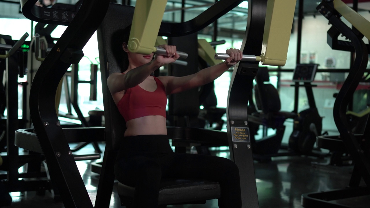 健身中心美女，健身器械在健身房健身，运动健身理念视频下载