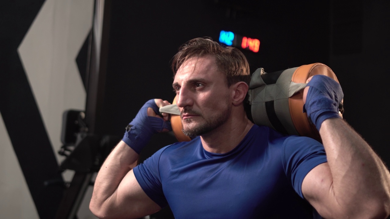 男人在健身房里提着重包健身，壮汉在健身房里健身视频下载