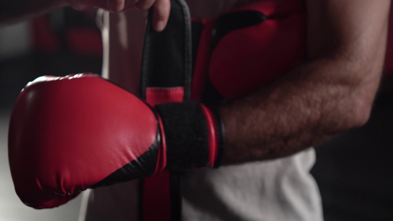 年轻的肌肉男拳击手在体育馆戴上拳击手套，运动员戴上拳击手套视频下载