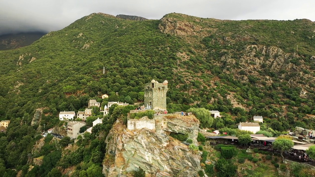 侬查村的塔位于干旱的绿色山脉中间，在欧洲，在法国，在科西嘉岛，靠近地中海的巴斯夏，在夏天，多云的日子里。视频下载
