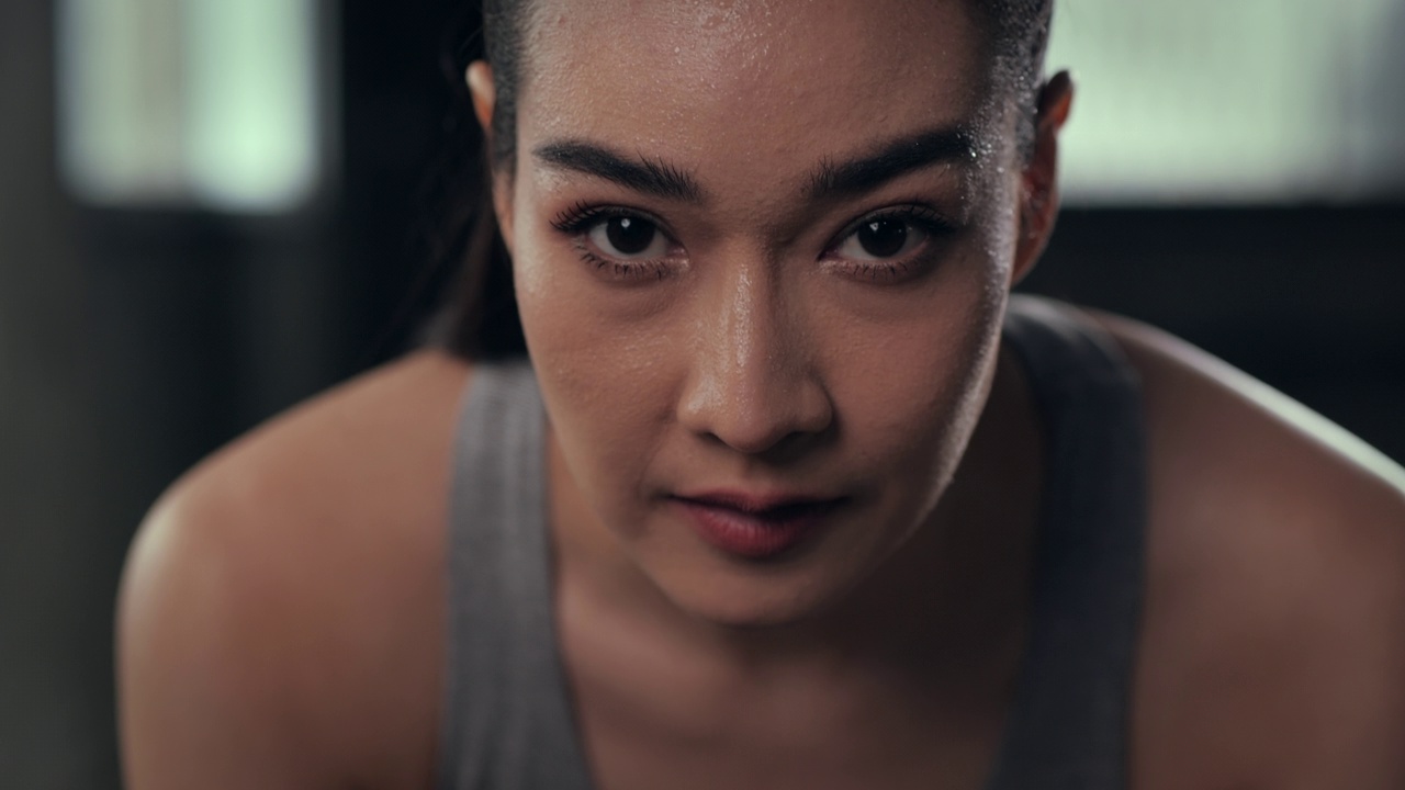 一个迷人的年轻女运动员在健身房锻炼休息时微笑。视频素材