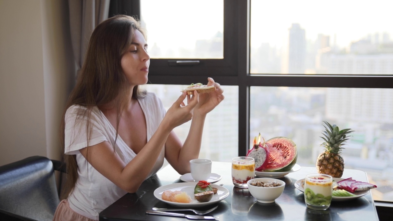 年轻快乐的女人正在吃新鲜，健康和美味的早餐视频下载