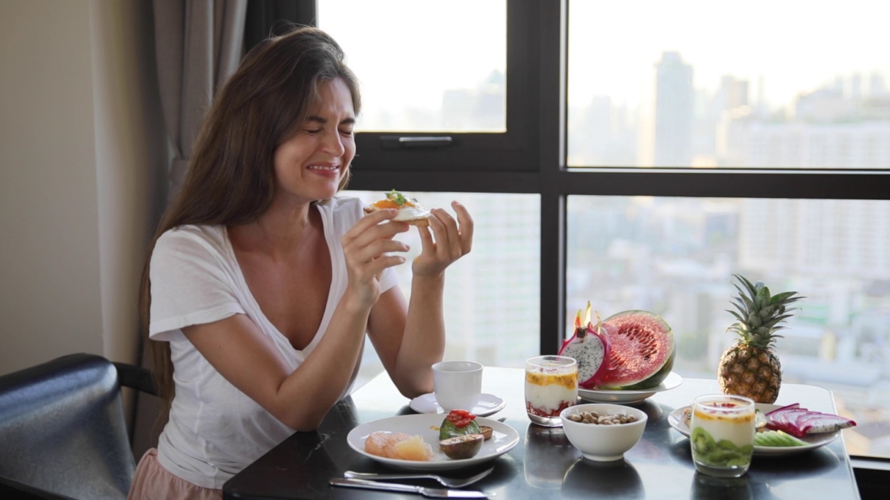 年轻快乐的女人正在吃新鲜，健康和美味的早餐视频下载