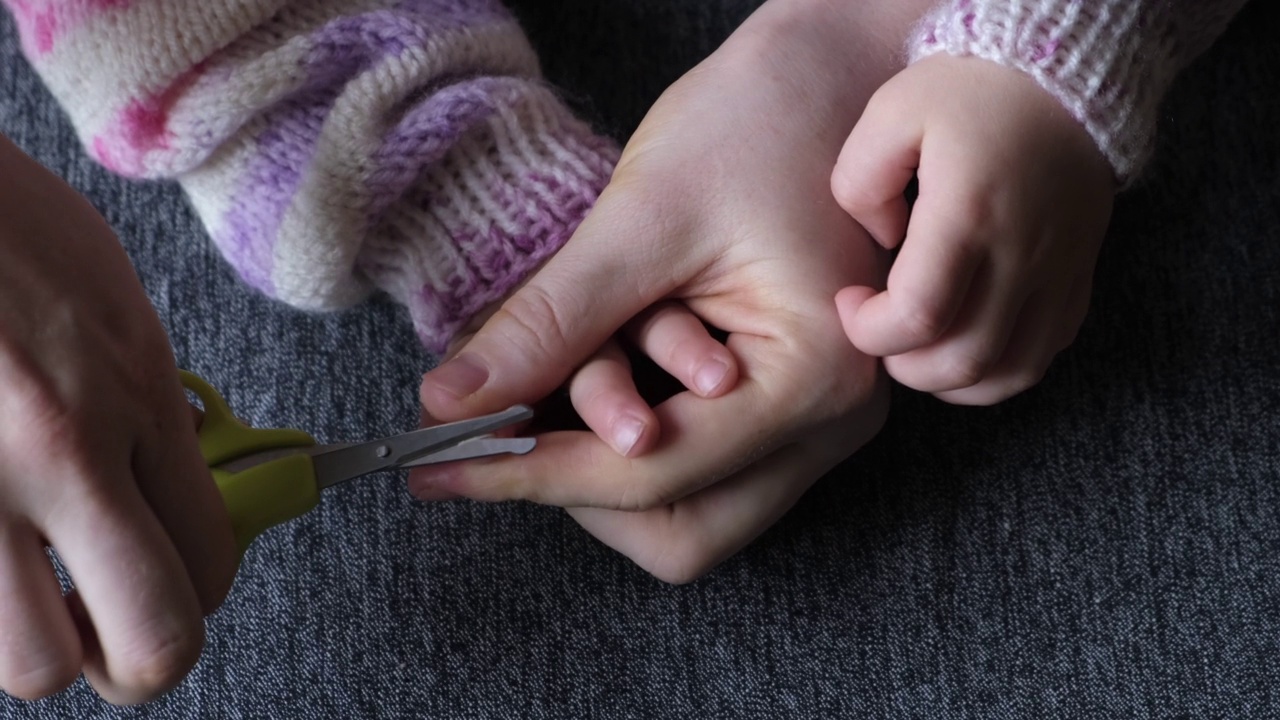 妈妈给小女儿剪指甲。视频下载