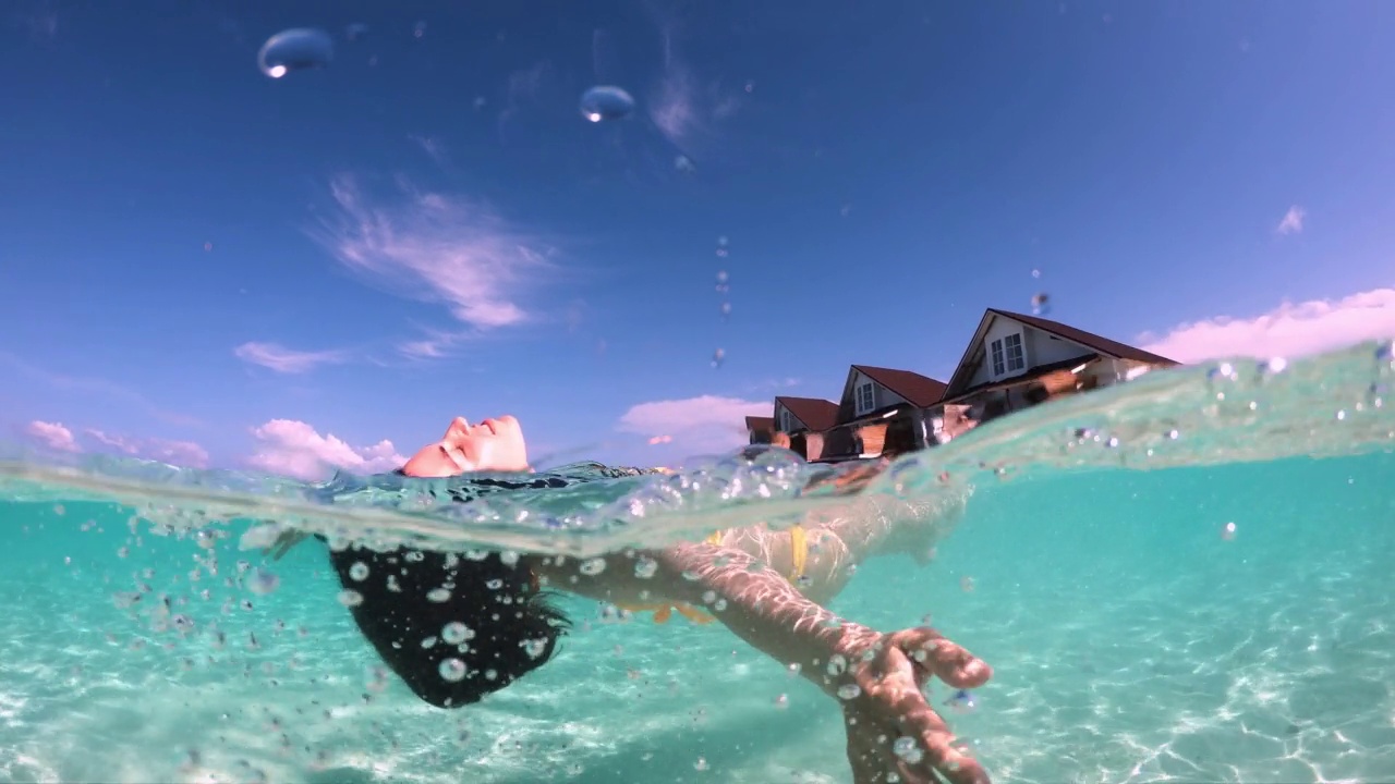 一个女人仰面漂浮在海里视频素材